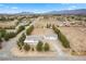 Expansive property featuring a main house with a covered porch and a large detached garage, situated on a desert landscape at 1160 Huracan St, Pahrump, NV 89048