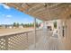 Back porch featuring lattice railing, wooden flooring with view of backyard and outbuildings at 1160 Huracan St, Pahrump, NV 89048
