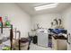 Functional laundry room with washing machine, sink, and storage shelves at 1160 Huracan St, Pahrump, NV 89048