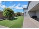 A charming backyard features artificial turf, patio pavers, mature trees, and privacy fencing at 1609 Dream Canyon Ave, North Las Vegas, NV 89084