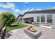 Relaxing backyard featuring a covered patio, fire pit, artificial turf, mature trees, and a barbeque at 1609 Dream Canyon Ave, North Las Vegas, NV 89084