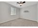 Bedroom with carpeted floors, ceiling fan, and a large window creates a relaxing atmosphere for rest at 1609 Dream Canyon Ave, North Las Vegas, NV 89084