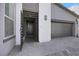 Front exterior featuring a modern gray stucco home with a front door with side slats at 1609 Dream Canyon Ave, North Las Vegas, NV 89084