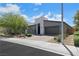 Modern single-story home with gray stucco, desert landscape, and a paved driveway at 1609 Dream Canyon Ave, North Las Vegas, NV 89084