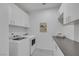 Neat laundry room with white washer and dryer, upper cabinets, and ample countertop space for folding at 1609 Dream Canyon Ave, North Las Vegas, NV 89084