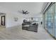 Bright living room with wood-look tile, modern fan, and open layout to the kitchen and dining areas at 1609 Dream Canyon Ave, North Las Vegas, NV 89084