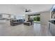 Open-concept living room with wood-look tile, modern fan, and large sliding glass doors to the backyard at 1609 Dream Canyon Ave, North Las Vegas, NV 89084