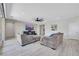 Spacious living room with wood-look tile, modern fan, and open layout to the kitchen and backyard at 1609 Dream Canyon Ave, North Las Vegas, NV 89084