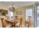 Dining area featuring a chandelier, bright windows, and a sliding glass door to the patio at 2037 Poppywood Ave, Henderson, NV 89012