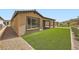 Backyard with artificial grass, stone perimeter, and view of the home at 243 Sun Glaze Ave, Henderson, NV 89011
