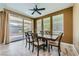 Dining room with a wooden table, six chairs, tile flooring, three windows, and sliding glass doors at 243 Sun Glaze Ave, Henderson, NV 89011