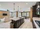 Open concept kitchen with island, quartz countertops, stainless appliances, and views of the living and dining areas at 243 Sun Glaze Ave, Henderson, NV 89011