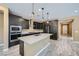 Modern kitchen with stainless steel appliances, dark wood cabinets, an island, and light wood-style floors at 243 Sun Glaze Ave, Henderson, NV 89011