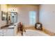 Relaxing bathroom features a soaking tub with a tiled surround and a vanity with decorative mirror at 25 Luce Del Sole # 3, Henderson, NV 89011