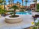 Inviting community pool area surrounded by lush greenery, lounge chairs, and shady palm trees at 25 Luce Del Sole # 3, Henderson, NV 89011