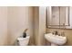 Classic powder room features a pedestal sink, framed mirror, and a decorative plant at 25 Luce Del Sole # 3, Henderson, NV 89011