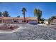 Charming one-story house with a tile roof, two-car garage, desert landscaping, and palm trees at 2699 Aldonza Dr, Henderson, NV 89014