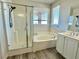 Bathroom features a bathtub, tiled shower with glass door, and single sink with storage cabinet at 2773 Drumlanrig St, Henderson, NV 89044