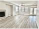 Bright living room featuring gray wood floors, fireplace, ceiling fan, and double doors to the backyard at 2773 Drumlanrig St, Henderson, NV 89044
