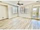 Bright living room featuring gray wood floors, ceiling fan, and double doors to the backyard at 2773 Drumlanrig St, Henderson, NV 89044