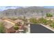 Neighborhood street view showcasing well-maintained homes, lush trees, and a scenic mountain backdrop at 3221 Birdwatcher Ave, North Las Vegas, NV 89084
