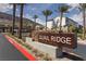Welcoming entrance to Quail Ridge with stone signage, lush landscaping, and stately palm trees at 378 Rosefinch St, Henderson, NV 89012