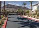 Gated community entrance with lush landscaping, palm trees, and mountain views beyond at 378 Rosefinch St, Henderson, NV 89012