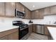 This is a kitchen with stainless steel appliances, white countertops, and wooden cabinets at 378 Rosefinch St, Henderson, NV 89012