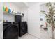Modern laundry room features side-by-side black appliances and white shelving at 378 Rosefinch St, Henderson, NV 89012