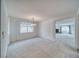 Open living room with soft carpet, chandelier, and a large window at 3891 Sedgwick, Pahrump, NV 89061