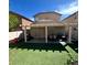 Backyard featuring artificial turf, a covered patio with outdoor seating and a grill at 4107 Macadamia Dr, Las Vegas, NV 89115