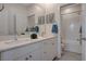 Bathroom featuring a double sink vanity, white cabinetry, and tiled shower at 513 Founders Creek Ave, North Las Vegas, NV 89084