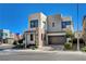 Modern two-story home with a two-car garage, stone accents, and beautiful landscaping against a bright blue sky at 513 Founders Creek Ave, North Las Vegas, NV 89084