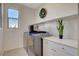 Clean laundry room with modern washer/dryer and sleek white countertops at 513 Founders Creek Ave, North Las Vegas, NV 89084