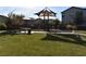 A playground with play structure and picnic table nestled within a green lawn area, perfect for outdoor recreation at 513 Founders Creek Ave, North Las Vegas, NV 89084