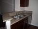Galley kitchen featuring a stainless sink, granite countertop, and wood cabinets at 5130 S Jones Blvd # 108, Las Vegas, NV 89118