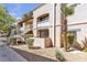 Condominium exterior featuring stucco walls, well-kept landscaping, and access stairs to upper level units at 5162 S Jones Blvd # 106, Las Vegas, NV 89118
