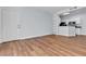Bright living room with wood flooring, a white door, and access to an open kitchen with granite countertops at 5162 S Jones Blvd # 106, Las Vegas, NV 89118
