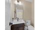 Stylish half bathroom with dark cabinets, white sink, and modern lighting fixtures at 6021 Vista Clara St, Las Vegas, NV 89148