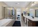 Bright primary bathroom with double sinks, soaking tub, glass shower, and doorway to bedroom at 6021 Vista Clara St, Las Vegas, NV 89148