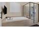 Modern bathroom with soaking tub and glass shower featuring sleek fixtures and tiled walls at 6021 Vista Clara St, Las Vegas, NV 89148