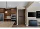 Kitchen featuring a stainless steel oven and microwave, wooden cabinets, granite countertop, and a door to the hidden pantry at 6021 Vista Clara St, Las Vegas, NV 89148