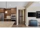 Kitchen featuring a stainless steel oven and microwave, wooden cabinets, granite countertop, and a peek into the hidden pantry at 6021 Vista Clara St, Las Vegas, NV 89148