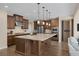 Bright kitchen features wood cabinetry, a large island with granite countertops, and modern pendant lighting at 6021 Vista Clara St, Las Vegas, NV 89148