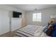 Cozy bedroom with mounted TV, plush carpet, and bright natural light at 6208 Rathbone St, Las Vegas, NV 89166