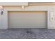 Attached garage with a brick driveway and neutral-toned door at 6208 Rathbone St, Las Vegas, NV 89166
