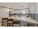 Open kitchen showcasing white cabinets, stainless steel appliances, and a large quartz countertop island with seating at 6208 Rathbone St, Las Vegas, NV 89166