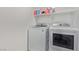 Modern laundry room featuring a white, front-load washer and dryer at 6208 Rathbone St, Las Vegas, NV 89166