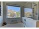 This bathroom features a shower with glass doors, a tub, and a view of the mountains at 6457 Lovett Canyon St, Las Vegas, NV 89148