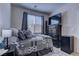 Cozy bedroom featuring a comfortable bed with stylish bedding, dark furniture, and natural light from the window at 6457 Lovett Canyon St, Las Vegas, NV 89148